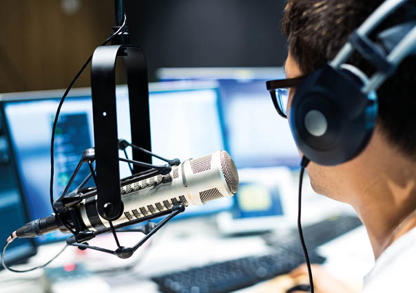 young man dj works in modern broadcast studio